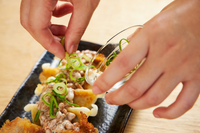 冷凍餃子の上に納豆、ネギとポン酢、ラー油をかける