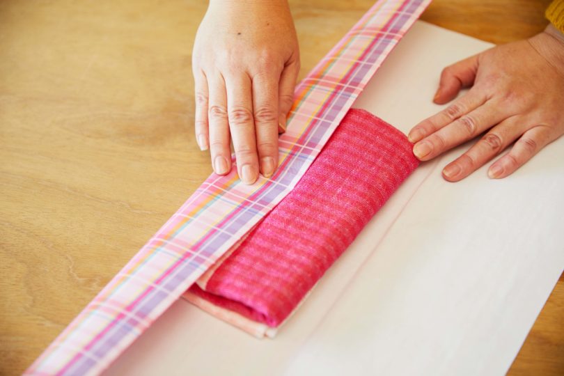 タオルの中心にステップ2の折り目が合わさるよう、包装紙を内側に折る。