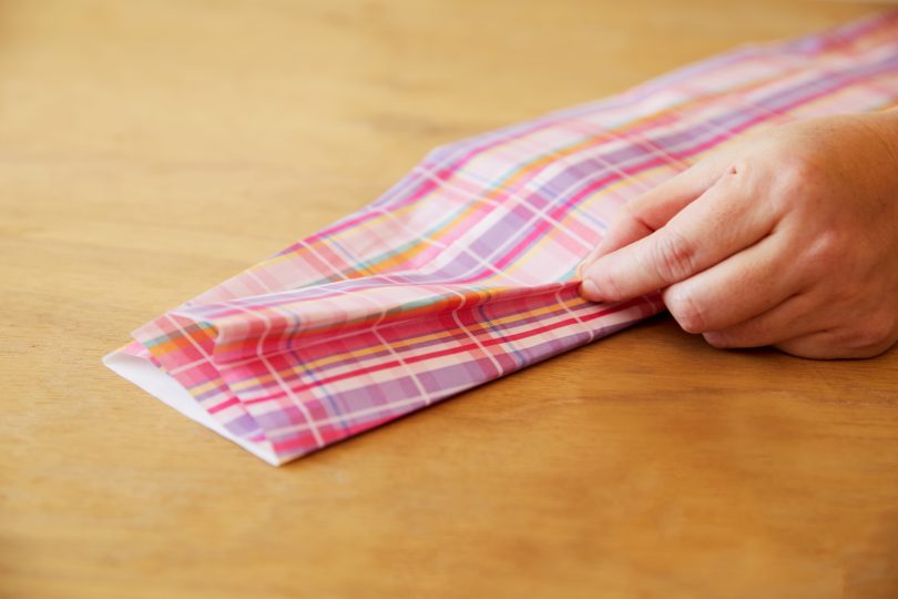左右のマチを端に向かって斜めに折り込む。