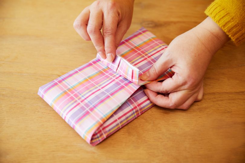 下は端をリボンの幅に合わせて折り込んでから、タオルに沿って内側に折る。