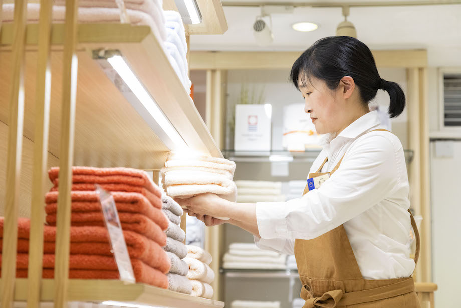 タオルを並べる女性スタッフ