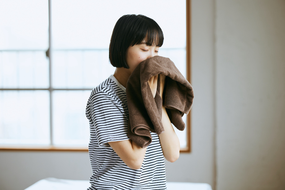 ピローケースを顔に当てる女性