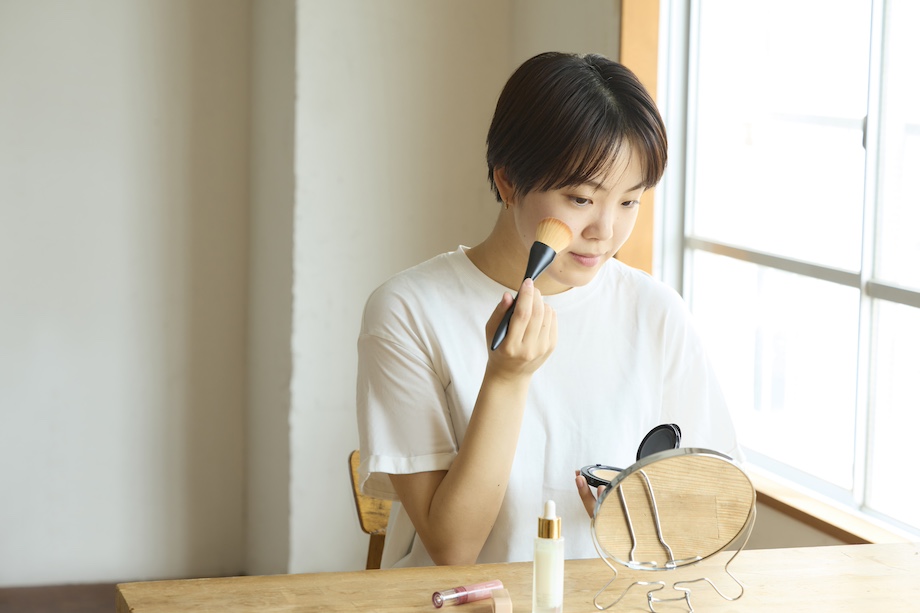 鏡を見ながらお化粧をする女性