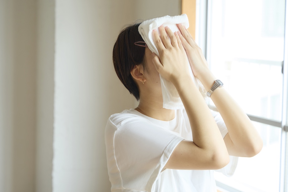 顔全体に蒸しタオルをあてている様子