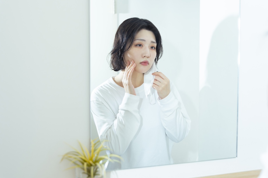 女性が鏡で肌の調子を確認する様子