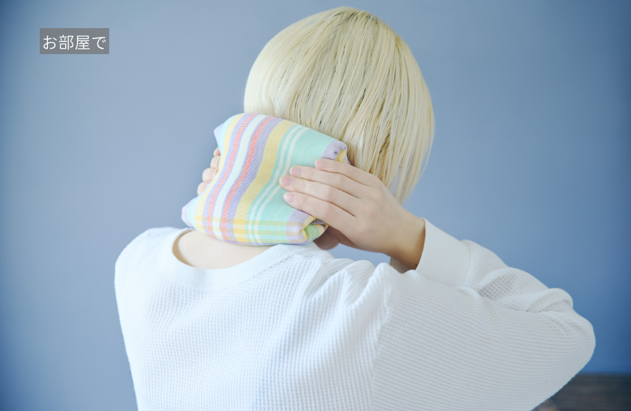 ホットタオルで首を温める女性