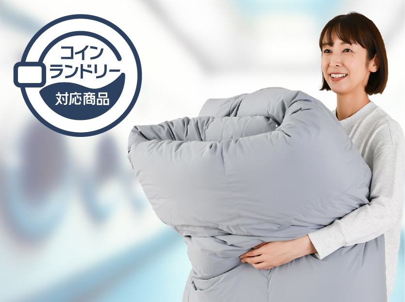 コインランドリーで洗える羽毛布団を抱える女性